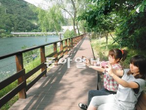 대청호 로하스 해피로드에 놀러온 문미숙(왼쪽), 정선영 씨가 주변의 풍광을 휴대전화 카메라에 담고 있다. 지명훈 기자 mhjee@donga.com