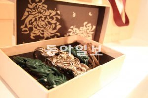 여러 가닥의 가죽줄을 엮어 국화꽃 이미지를 표현한 헬레닉제인의 핸드백줄.