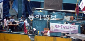 정리해고로 6개월째 노사분규를 겪고 있는 한진중공업 부산 영도조선소 노조원들이 16일 작업장에 모여 향후 사태에 대해 심각한 표정으로 이야기를 나누고 있다. 주변에 ‘여보∼ 꼭 이기고 돌아와∼’ 등 붉은 글씨로 쓰인 플래카드들이 걸려 있다. 부산=최재호 기자 choijh92@donga.com