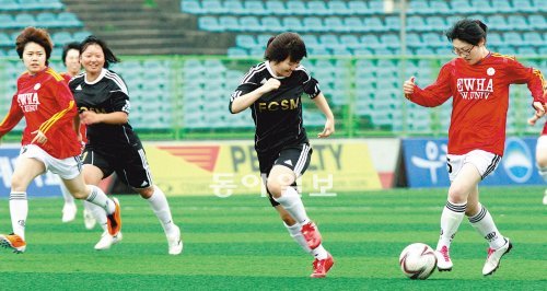 ‘여대 축구 마니아의 치열한 한판 승부!’ 이화여대와 숙명여대의 축구 동아리 팀 선수들이 23일 서울 효창운동장에서 열린 친선경기에서 장대비 속에서도 그라운드를 누비며 경기를 펼치고 있다. 김미옥 기자 salt@donga.com