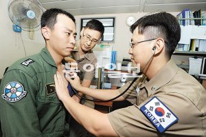 청해부대 장재훈 대위(오른쪽)가 의무실에 찾아온 장교를 진료하고 있다. 해군본부 제공