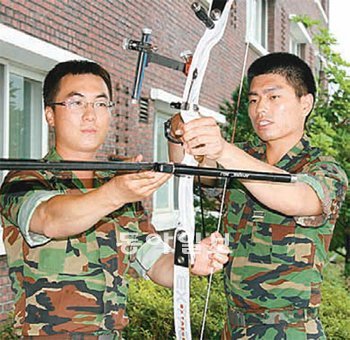 육군 1107공병단 약진부대 백현 일병(오른쪽)과 그의 멘토 김선만 중대장이 양궁선수용 활을 살펴보며 대화를 나누고 있다. 국방부 제공