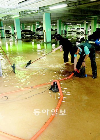 중부지역에 큰비가 쏟아진 12일 경기 김포시 장기동 김포한강신도시 내 한 아파트 주차장이 침수돼 주민들이 배수 작업을 하고 있다. 김포=홍진환 기자 jean@donga.com