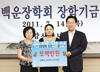 실종자 수색 봉사활동을 하다 익사한 임정식 씨의 어머니 강은희 씨(왼쪽) 등 유족이 14일 이성웅 전남 광양시장(오른쪽)에게 장학금을 전달하고 있다. 광양시 제공
