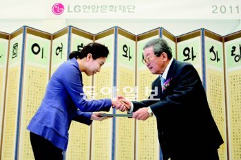 구자경 LG그룹 명예회장(오른쪽)이 18일 서울 여의도 LG트윈타워에서 열린 ‘연암 해외 연구교수 증서 수여식’에서 성균관대 신문방송학과 금희조 교수에게 연구비 지원증서를 주고 있다. LG그룹 제공