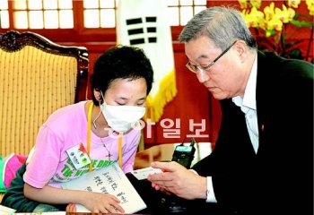 백혈병으로 투병 중인 이현경 양(왼쪽)이 19일 서울 종로구 도렴동 외교통상부를 방문해 김성환 외교부 장관과 만나 김 장관의 명함에 적힌 트위터 계정을 보고 있다. 이 양의 장래 희망은 외교관이다. 박영대 기자 sannae@donga.com