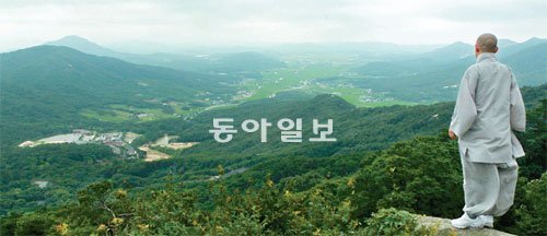 충남 예산군 덕숭산 금선대 부근 바위에서 바라본 수덕사(왼쪽 아래). 그 앞 저 멀리 홍성읍이 손에 잡힐 듯 한눈에 내려다보인다. 상왕산(개심사)-가야산(가야사)-덕숭산(수덕사)으로 이어지는 내포 가야산 일대는 한때 절집이 100개를 넘었을 정도로 ‘부처의 꽃심땅’이었다. 일제강점기 경허, 만공선사가 선풍을 일으킨 곳도 역시 이곳 내포 땅이었다. 경허는 활달하여 거침이 없었다. 만공은 따뜻하고 소탈했다. 경허는 끝내 이름을 바꾸고 저잣거리에 몸을 숨겼다. ‘어촌이나 주막집/어찌 숨을 곳이야 없으랴마는/감출수록 그 이름 더 새롭게 알려질까/다만 그것을 두려워하노라.’ 만공은 스승의 시신을 거두고 덕숭산에서 묵묵히 제자를 길렀다. 예산 수덕사=서영수 전문기자 kuki@donga.com