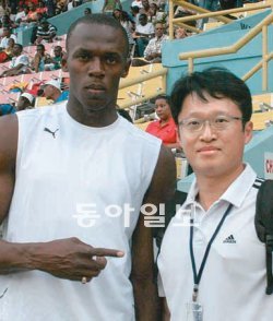 우사인 볼트(왼쪽)는 팬들과 사진을 찍을 때도 익살스러운 포즈를 잘 취한다. 양종구 기자(오른쪽)가 2009년 2월 자메이카 킹스턴의 내셔널스타디움에서 만났을 때는 손가락으로 기자를 가리켰다. 동아일보DB