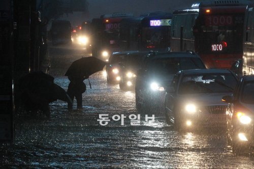 물바다 된 서울시청 앞 도로 26일 오후 서울에 시간당 70mm의 폭우가 쏟아지면서 서울 곳곳이 침수됐다. 서울시청 앞 도로에서 시민들이 정강이까지 차오른 물을 헤치며 걸어가고 있다. 장승윤 기자 tomato99@donga.com