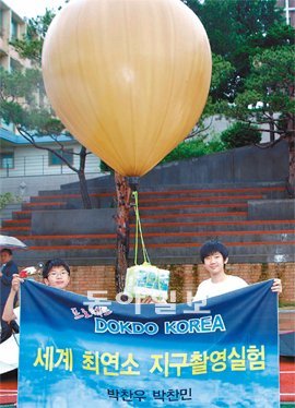 28일 오후 서울 동대문구 신설동 대광중학교 운동장에서 박찬우 군(오른쪽)과 동생 찬민 군(왼쪽)이 한반도와 독도 영상을 촬영하기 위해 풍선로켓을 발사한 뒤 기념 플래카드를 들고 기뻐하고 있다. 정진욱 기자 coolj@donga.com