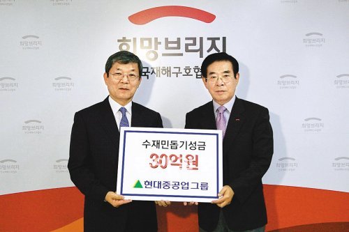 이재성 현대중공업 사장(왼쪽)이 31일 한중광 전국재해구호협회 상임이사에게 수재민 성금을 전달하고 있다. 현대중공업 임직원은 지난달 27∼31일 서울 부산의 수해지역에서 자원봉사활동을 하기도 했다. 현대중공업 제공