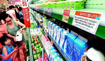 원유 가격 인상 문제를 놓고 낙농업계와 우유업계가 분쟁을 벌이는 가운데 서울시내 한 대형마트의 군데군데 비어 있는 우유 매대에서 손님들이 우유를 고르고 있다. 낙농업계는 3일 하루 동안 원유 공급을 중단하겠다고 선언했다. 박영대 기자 sannae@donga.com