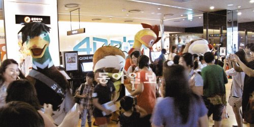 지난달 31일 서울 용산구 한강로 용산CGV에서 관객들이 ‘마당을 나온 암탉’에 등장하는 캐릭터 인형들을 보며 즐거워하고 있다. 명필름 제공