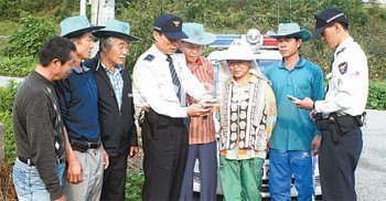 경찰이 마을지킴이들에게 휴대전화 단축번호를 통한 신고방법을 알려주고 있다. 마을 지킴이들은 휴대전화 신고만으로 범죄 예방 역할을 톡톡히 한다. 경북경찰청 제공