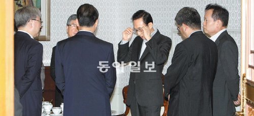 심각한 李대통령 8일 미국의 신용등급 하락이 우리 경제에 미칠 영향을 점검하기 위해 열린 청와대 경제금융상황점검회의에서 이명박 대통령(가운데)이 심각한 표정으로 안경을 고쳐 쓰며 박재완 기획재정부 장관, 김석동 금융위원장, 김중수 한국은행 총재 등 참석자들과 대화를 나누고 있다. 김동주 기자 zoo@donga.com