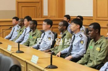 해적인 무함마드 아라이(23) 아울 브랄라트(19) 압둘라 알리(24) 압디카다르 이만 알리(21)가 교도관을 사이에 두고 피고인석에 앉아 있다(왼쪽부터). 재판부는 해적이 보복할 것을 우려해 교도관의 얼굴 사진은 모자이크 처리해 달라고 주문했다. 아울 브랄라트는 미성년자여서 같은 처리를 했다. 부산=최재호 기자 choijh92@donga.com