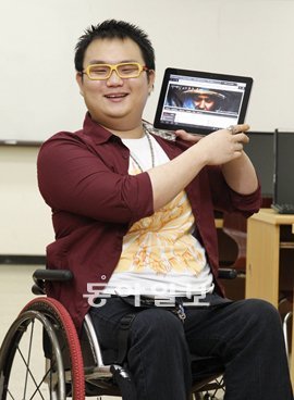 하반신 마비를 딛고 e스포츠 심판으로 활약하게 되는 고석찬 씨(23)가 태블릿 PC에 장애인 e스포츠 동호회 인터넷 카페 홈페이지를 띄우고 환하게 웃고 있다. 김재명 기자 base@donga.com
