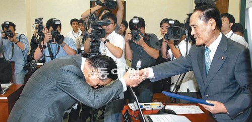 ‘조남호 청문회’ 증인 선서문 제출 조남호 한진중공업 회장(왼쪽)이 18일 국회 환경노동위원회에서 열린 ‘한진중공업 청문회’에서 김성순 환노위원장에게 증인 선서문을 제출한 뒤 고개를 깊이 숙인 채 악수하고 있다. 사실상 ‘조남호 청문회’로 진행된 이날 조 회장은 한진중공업 사태 장기화에 대한 여야 의원들의 비판에 해명하느라 진땀을 흘렸다. 전영한 기자 scoopjyh@donga.com