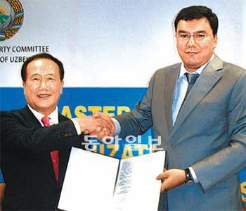김봉수 한국거래소 이사장(왼쪽)과 압두 카키모프 우즈베키스탄 국유재산위원장이 한국 증시시스템을 수출하는 내용의 계약을 체결한 뒤 악수를 하고 있다.