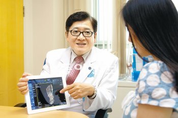 경기 분당서울대병원 정형외과 의사가 병실에 있는 환자에게 발뼈를 찍은 X선 영상을 태블릿PC 화면으로 보여주며 치료 방식을 설명하고 있다. 의료진의 태블릿PC는 클라우드 기반 진료정보시스템에 연결돼 있다. 분당서울대병원 제공