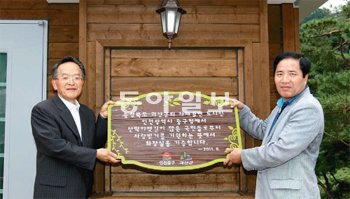 김홍복 인천 중구청장(오른쪽)이 임각수 괴산군수에게 화장실 건립 기증패를 전달하고 있다 괴산군 제공