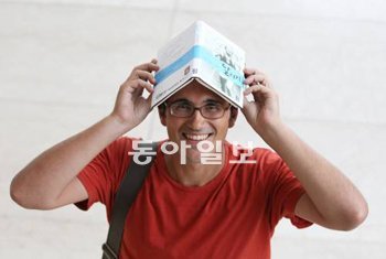 국내 출판사 기획팀장으로 일하는 벨기에인 그레고리 림펜스 씨가 자신이 재출간한 소설 ‘달리기’를 머리에 얹으며 장난스러운 포즈를 취하고 있다. 장승윤 기자 tomato99@donga.com