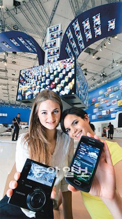 2일(현지 시간) 독일 베를린에서 열리는 ‘IFA 2011’ 전시회를 앞두고 모델들이 삼성전자의 운영체제(OS) 바다 2.0이 탑재된 스마트폰 ‘웨이브3’와 디지털카메라 ‘NX200’ ‘MV800’을 소개하고 있다. 삼성전자 제공