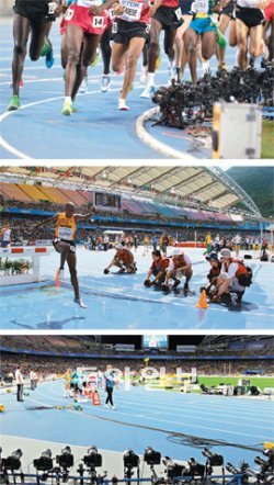 대구 세계육상선수권대회에서 좋은 사진을 얻기 위한 취재 경쟁이 선수들의 경쟁 못지않게 치열하다. 사진기자들은 경기에 방해가 되거나 사람이 직접 찍기 위험한 지점에는 원격 무선 조종 카메라를 설치한다(위). 장애물 달리기에서 물이 튀는 생생한 장면을 포착하기 위해선 옷이 젖는 것을 감수해야 한다(가운데). 출발선을 향해 빽빽이 늘어선 첨단 카메라 장비들(아래). 대구=김경제 기자 kjk5873@donga.com·변영욱 기자 cut@donga.com