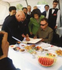 8월 21일 러시아 극동지역의 부레야 발전소를 찾아 방명록에 서명하는 김정일 국방 위원장 뒤에서 김옥이 서명을 돕고 있다.