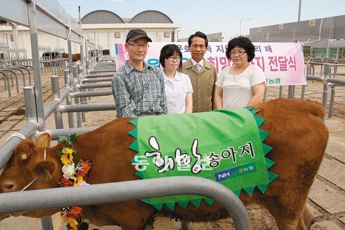 김용복 농협 전남지역본부장(오른쪽에서 두 번째)이 5일 다문화가정 자녀인 박가영 양에게 ‘희망 송아지’를 전달하고 있다. 농협 전남지역본부 제공