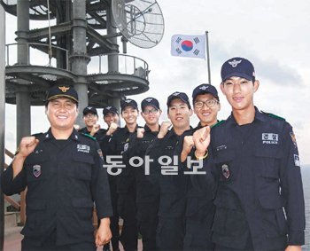 이승수 독도경비대장(왼쪽)과 대원들이 추석을 앞둔 9일 동아일보의 요청으로 경비시설 옆 태극기 게양대에 모여 늠름한 모습을 보여주고 있다. 독도경비대 제공
