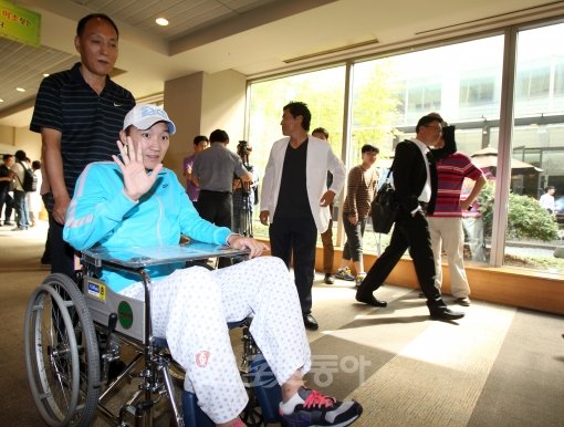 축구선수 신영록이 16일 오후 서울 강남구 일원동 삼성서울병원에서 열린 퇴원 인터뷰를 마치고 휠체어로 이동하며 손을 들어 인사를 하고 있다. 국경원 기자 onecut@donga.com 트위터@k1isonecut