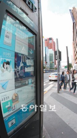 전기 쓰고 외면받는 거리 미디어폴 20일 미디어폴이 설치된 서울 강남역 부근 도로를 시민들이 걷고 있다. 미디어폴의 화면에는 하루 종일 뉴스와 날씨 정보 등이 돌아가지만 이를 들여다보는 사람은 드물었다. 19일 이후 날씨가 선선해졌지만 서울 시내 매장 곳곳에서는 한기가 느껴질 정도로 에어컨을 틀어놓는 등 전력을 낭비하는 모습을 볼 수 있었다. 양회성 기자 yohan@donga.com