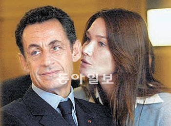 니콜라 사르코지 프랑스 대통령에게 부인인 카를라 브루니 여사(오른쪽)가 귓속말을 하고 있다. 동아일보DB