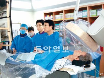 박승정 교수(오른쪽)와 서울아산병원 심장 스텐트 중재시술팀이 볼펜 스프링처럼 생긴 스텐트를 허벅지를 통해 혈관 속으로 집어넣고 있다. 이 팀은 국내 최다 스텐트 수술
건수를 기록했다. 홍진환 기자 jean@donga.com