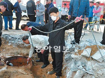 지난달 28일 폭발사고로 2명이 부상한 경기 화성시 A주유소에서 경찰이 유사석유 보관 탱크와 연결 호스를 살펴보며 사고 경위를 조사하고 있다. 화성동부경찰서 제공