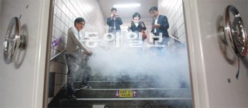 지난달 30일 오후 서울지하철 5호선 신금호역 입구에서 소방방재청 관계자 등이 연기를 발생시켜 화생방 방호시설이 이를 잘 막는지 시험하고 있다. 합금 철문에 부착된 원형 핸들을 돌리면 열리고 잠긴다. 김미옥 기자 salt@donga.com