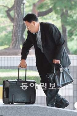 여행용 가방 들고… 현 정부 실세에게 금전을 제공했다는 의혹을 폭로한 이국철 SLS그룹 회장이 3일 오전 검찰 조사를 받기 위해 서울 서초동 서울중앙지검으로 법인카드 사용명세 자료 등이 담긴 여행용 가방을 끌고 들어가고 있다. 양회성 기자 yohan@donga.com