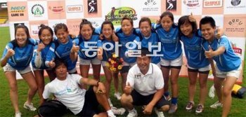 한국 여자 럭비 사상 처음으로 국제대회에서 승리를 따낸 한동호 감독(앞줄 오른쪽)과 강동호 코치(앞줄 왼쪽), 그리고 10명의 대표 선수가 2일 아시아 여자 7인제 대회 라오스전에서 승리한 후 밝게 웃고 있다. 대한럭비협회 제공