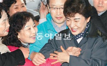 “손이라도 잡아보자” 부산 동구청장 재선거 지원을 위해 자성대노인복지회관을 방문한 박근혜 전 한나라당 대표(오른쪽)의 손을 한 여성이 당기고 있다. 가운데 남성이 한나라당 정영석 후보. 부산=최재호 기자 choijh@donga.com