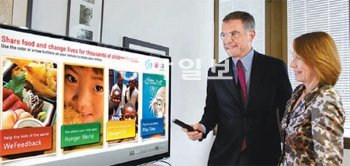 17일(현지 시간) 이탈리아 로마의 유엔 세계식량계획(WFP) 본부에서 LG전자 이탈리아법인 프란체스코 마르체세 마케팅 이사(왼쪽)가 WFP 낸시 로먼 대외담당 이사에게 스마
트TV로 곧바로 기부를 할 수 있는 ‘위피드백’ 앱을 시연해 보이고 있다. LG전자 제공