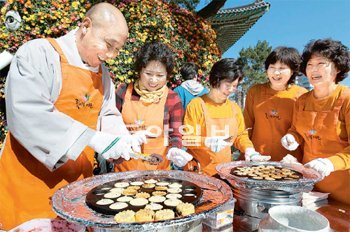 19일 오전 서울 종로구 견지동 조계사 대웅전 앞에서 주지 토진 스님이 국화를 주제로 한 축제를 앞두고 신도들과 국화빵을 굽고 있다. 스님은 “국화만 보지 말고 주지스님표 국화빵도 맛보기 바란다”고 말했다. 김미옥 기자 salt@donga.com