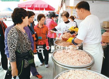 19일 오전 충남 논산시 강경읍의 젓갈축제장을 찾은 관람객들이 젓갈을 구입하고 있다. 상인들이 정량 이상을 주는 덤이 젓갈축제의 큰 매력이다. 논산시 제공