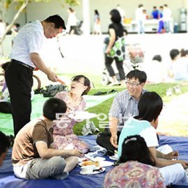 세계로교회 앞 잔디밭에서 식사를 하며 편안하게 이야기를 나누고 있는 신자들. 부산=임희윤 기자 imi@donga.com