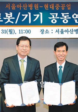 31일 서울 송파구 풍납동 서울아산병원에서 김외현 현대중공업 대표이사(오른쪽)와 박성욱 서울아산병원장이 ‘현대중공업-서울아산병원, 의료용 로봇 기기 공동 연구 협약’을 맺었다. 현대중공업 제공