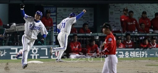 삼성의 한국시리즈 우승을 결정한 한 방이었다. 5차전 4회말 좌월 결승 솔로포를 터뜨린 삼성 강봉규(왼쪽)가 1루를 돌며 타구가 담장을 넘어가는 것을 확인한 후 주먹을 불끈 들어올리며 환호하고 있다. 김평호 1루코치(71번) 역시 한 팔을 들어 올렸다. 잠실｜임진환 기자 photolim@donga.com 트위터 @binyfafa