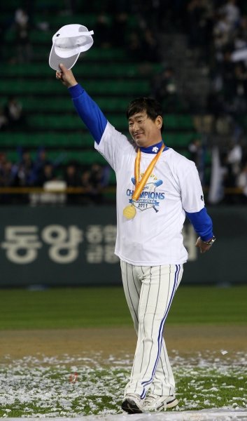 부임 첫해에 삼성을 우승으로 이끈 류중일 감독이 우승 기념 티셔츠를 입고 우승 메달을 목에 건 채 모자를 들어 보이며 팬들의 환호에 답하고 있다.  잠실｜국경원 기자 onecut@donga.com 트위터 @k1isoncut