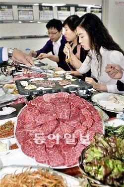 직장인들이 마장동 시장에서 사온 한우를 ’고기 익는 마을’에서 구워 먹으며 이야기를 나누고 있다. 앞쪽에 보이는 1등급 한우모둠구이(1kg)를 8만 원에 즐길 수 있다. 성동구 제공