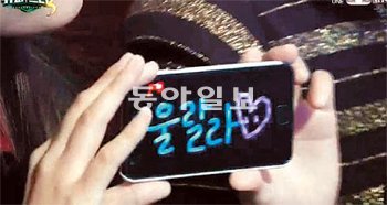 지난달 28일 열린 슈퍼스타K3 생방송을 관람하는 관객이 스마트폰에 ‘울랄라세션’의 이름을 적어 응원하고 있다.Mnet TV 화면 촬영
