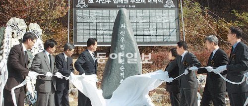 4일 열린 차선우 집배원의 추모비 제막식에서 우정사업본부 및 지식경제부 관계자들이 추모비의 장막을 걷어내고 있다. 우정사업본부 제공